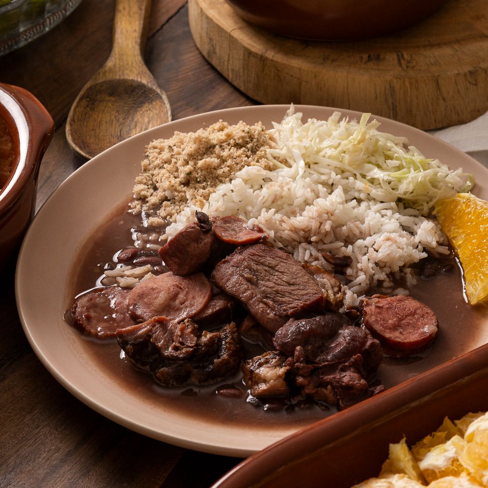 Prato de feijoada com acompanhamentos